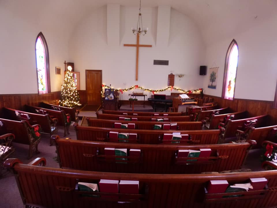 Church sanctuary interior with wooden pews and cross